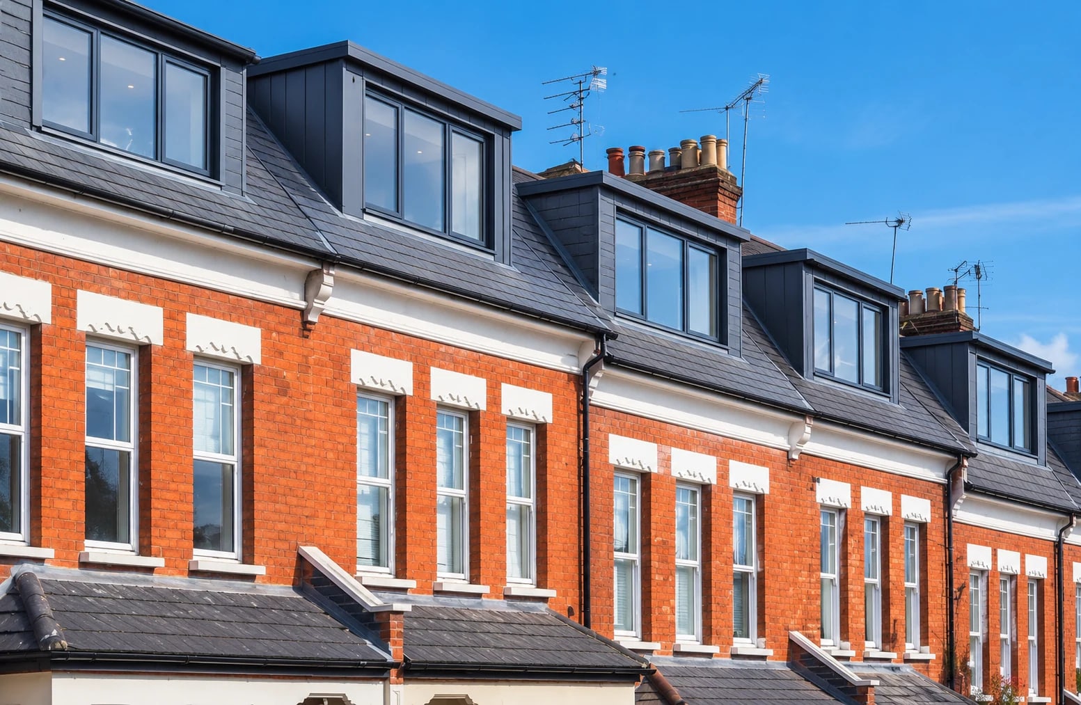 A row of Oxford brick terraces with contemporary dormer windows projecting from the slate roof