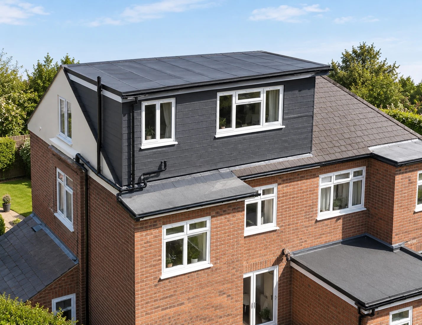 A brick house with a new vertical gable end and a large rear dormer, showing a completed hip-to-gable loft conversion