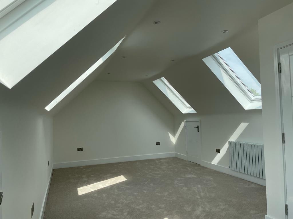 Empty loft room lit by two Velux rooflights in Oxford